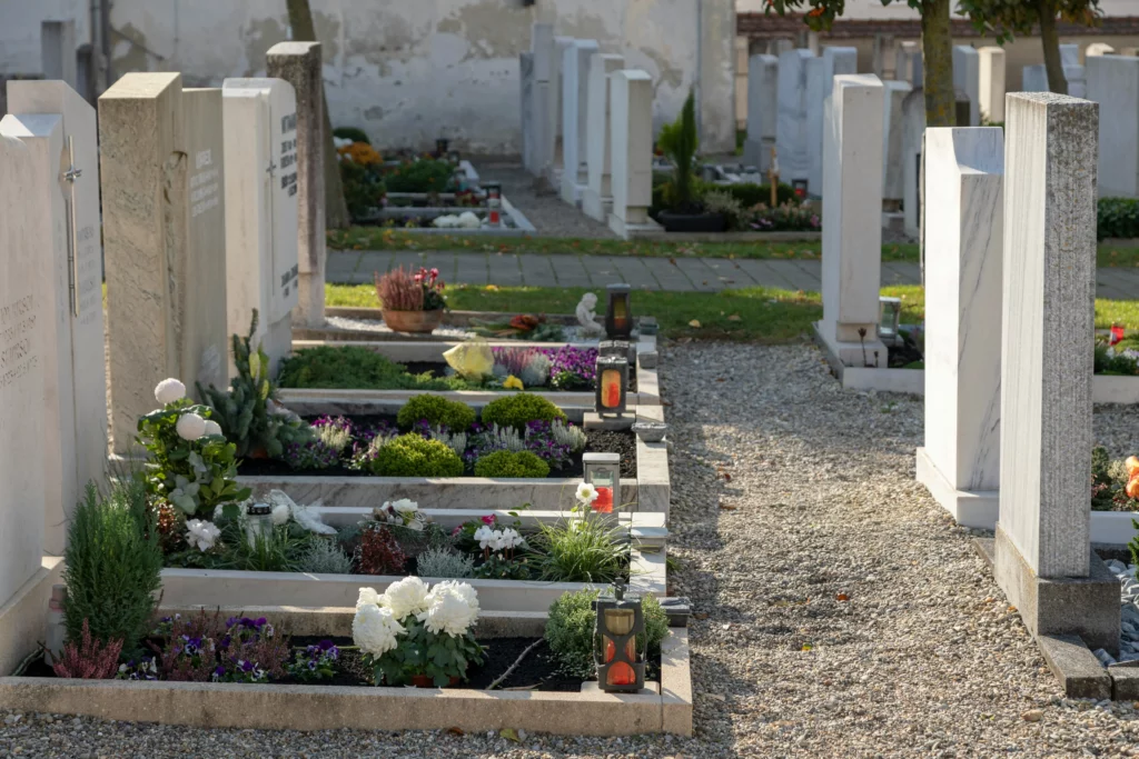 Tombes et sépultures soigneusement fleuries dans les allées d'un cimetière.